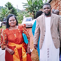 Dr. Bailey in Uganda doing an away rotation while a resident at the University of Arizona, visits the host family that he stayed with during his undergrad semester abroad in 2002. The woman is the mother of the family. He was studying natural medicine at the time (2017). 