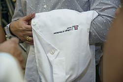 A student waits with UA College of Medicine white coat over his arm
