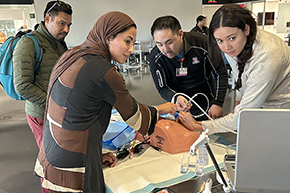 [Dr. Ryan Wong shows students how to place a central line catheter into a vein that goes to the heart.]