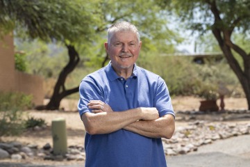 [Melvin Hector, MD, stands outside wearing a blue shirt. ]