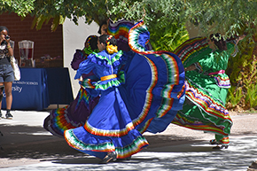 [Dancers from the U of A Folklorico Program sashay and swing their skirts on traditional Mexican dresses at the UAHS Hispanic Heritage Month Celebration.]