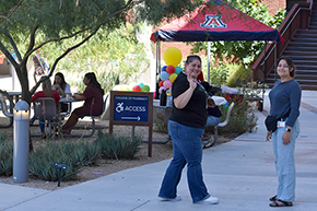 [Carmen Ramos and Stephanie Clinch, from the Division of Gastroenterology & Hepatology, enjoy the music at the UAHS Hispanic Heritage Month Celebration.]