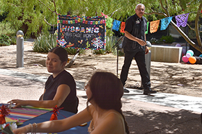 [Finished speaking, Dr. Francisco Moreno walks past "Hispanic Heritage Month" poster at celebration hosted by UAHS Office of Equity, Diversity & Inclusion.]