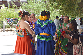 [U of A Folklorico dancers chat after performing at the UAHS Hispanic Heritage Month Celebration.]