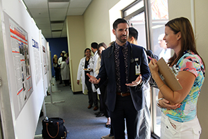 Dr. Roberto Swazo discusses his poster with judge Chris Foreman-Goerke