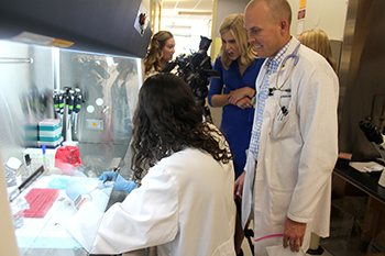 KVOA reporter Kendra Hall makes face at dissection of kissing bugs as Dr. Norm Beatty watches
