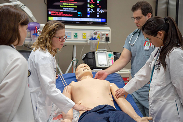 Image of Dr. Laura Meinke working with students in the ASTEC sim lab at the UA College of Medicine - Tucson