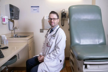 [Portrait of Aaron Scott, MD, in a patient room]
