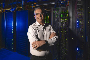 [Researcher in front of supercomputer]