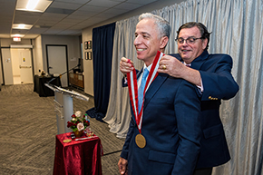 [College of Medicine – Tucson Dean Michael Abecassis, MD, MBA, places the investiture medallion on Hesham Sadek, MD, PhD, Cardiology division chief and Sarver Heart Center director.]