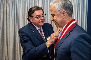 [Hesham Sadek, MD, PhD, Cardiology division chief and Sarver Heart Center director, smiles as College of Medicine – Tucson Dean Michael Abecassis, MD, MBA, places special lapel pin on him during investiture ceremony.]