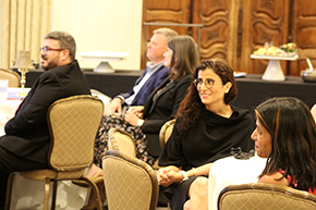 [Two ladies at right – and others seated above them – listen and smile as another U of A Department of Medicine faculty member is raved about by their division chief.]