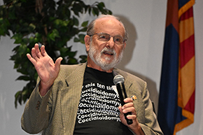 [Older white man with beard gestures while discussing development of a vaccine to prevent Valley fever infections in dogs and a potential human vaccine at a panel discussion at the AZBio Week festivities in Phoenix.]