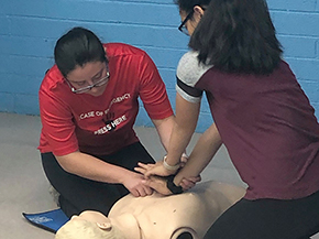 Health education assistant Erika Yee trains a high school student on chest-compression-only CPR techniques