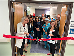 Scissor wielders Naphtali Kahl, RN (in white coat), and Brittany Davis, RN (right), director associate director of cardiology services at Banner – University Medical Center South, cut the ribbon to reopen the cardiac cath lab, which was renovated over the past year.