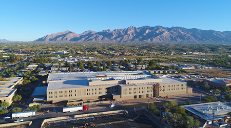 Aerial photo looking north toward Catalina Mountains of the Banner – University Medicine North campus with (at left) the UArizona Cancer Center's Peter & Paula Fasseas Cancer Clinic and (larger structure at right) Building 2, which houses outpatient physician clinics