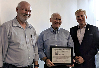 Terry Smith (center), receiving his Wildcat Family Spirit Award last fall, from Dr. Yves Lussier (right), director of the UAHS Center for Biomedical Informatics and Biostatistics
