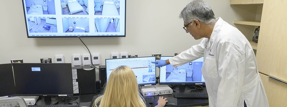 Sairam Parthasarathy, MD, director of the University of Arizona Health Sciences Center for Sleep, Circadian and Neuroscience Research, reviews test data in the control room of the center’s new facility with lead sleep technologist Sicily La Rue.