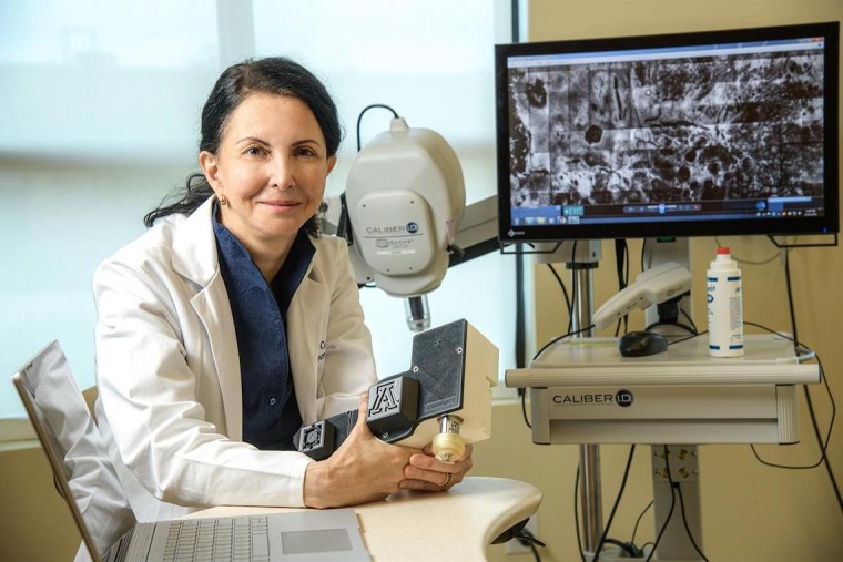 [Clara Curiel-Lewandrowski, MD, FAAD, with confocal microscope designed to better analyze and track potentially malignant lesions on the skin]