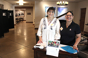 [Carolyn Bothwell (Division of Infectious Diseases) and Melody Ayon (Division of Endocrinology) assist in checking in attendees at the Docs in the Kitchen event at the Hacienda at the River senior living community.]