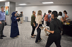 [Students, residents and chief residents line up for crabcakes, mini-chimichangas, breaded chili peppers and other sundry food items for snacks at the Internal Medicine Student Meet-and-Greet.]