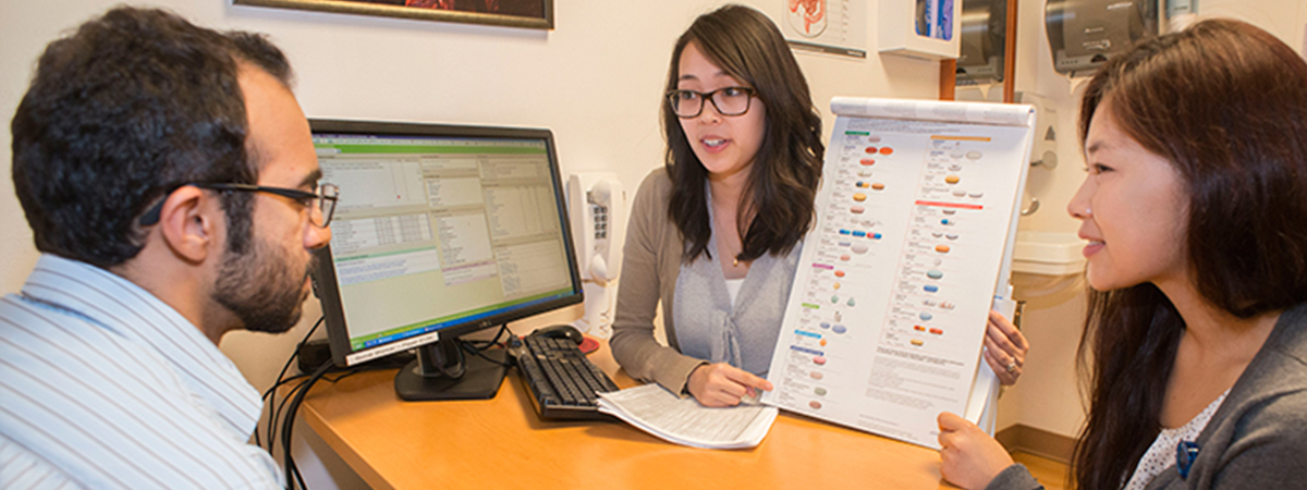 Connie Chan, PharmD, (center) counsels a patient at the Petersen HIV Clinic. 