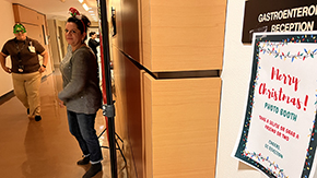 [GI fellowship coordinator Maria Longoria, with Carmen Ramos on left, brought in her photo booth displays and props from home to help make this season a little more festive for colleagues.]