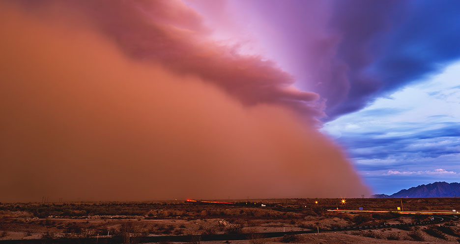 A haboob, or massive dust storm, swirls across a rural Arizona desert landscape.