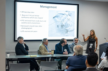 [U of A Surgery's Dr. Taylor Riall (right) points at the screen as fellow panelists – including Dr. Oleh Haluszka (2nd from left) and attendees listen during inaugural  Hepato Pancreato-Biliary CME Seminar. (Photo: U of A Cancer Center)]