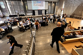 [The awards ceremony gets under way, with COM-T vice dean and GGP Division’s Kevin F. Moynahan, MD, at the podium and Cardiology’s Tushar Acharya, MD, MPH, walking down the steps.]