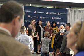 [WIMS GRACE Excellence Award winners, including Hematology & Oncology division chief Rachna Shroff, MD, MS (in yellow dress), take their turn onstage to allow friends and family take their pictures together after the COM-T Faculty Awards ceremony – as Dr. Kevin Moynahan and others look on.]