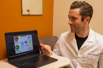 Pointing to an image on a laptop computer, Daniel Butler, MD, discusses how aging changes conditions in our skin.