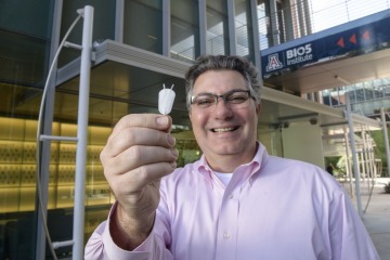 [Klearchos Papas, PhD, holds a synthetic nanoporous pouch used in an implantable cell therapy device to provide insulin for Type 1 diabetes patients. (Photo, UArizona Health Sciences, Kris Hanning)]