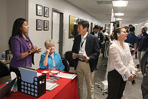 [DOM Chair James Liao, MD (center), consults with Jazmine Aguilar (left), an Internal Medicine Residency Program admin, on logistics of the poster contest and judging; while IM Residency Program director Laura Meinke, MD (right), chats with a colleague]