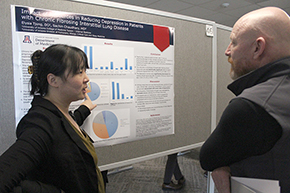 [Elysia Tjong, DO, discusses her poster, “Impact of Resources in Reducing Depression in Patients with Chronic Fibrosing Interstitial Lung Diseasee,” with Franz Rischard, DO, director of the Pulmonary Hypertension Program]