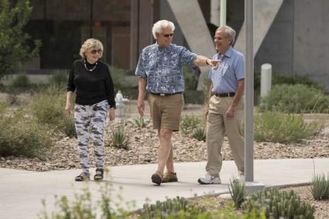 [Three older adults walk through the University of Arizona Health Sciences campus]