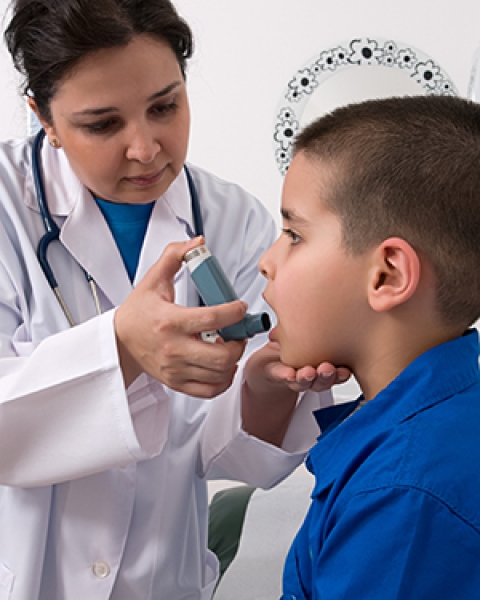 A child gets help with an asthma inhaler
