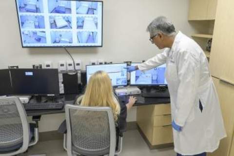 Sairam Parthasarathy, MD, director of the University of Arizona Health Sciences Center for Sleep, Circadian and Neuroscience Research, reviews test data in the control room of the center’s new facility with lead sleep technologist Sicily La Rue.