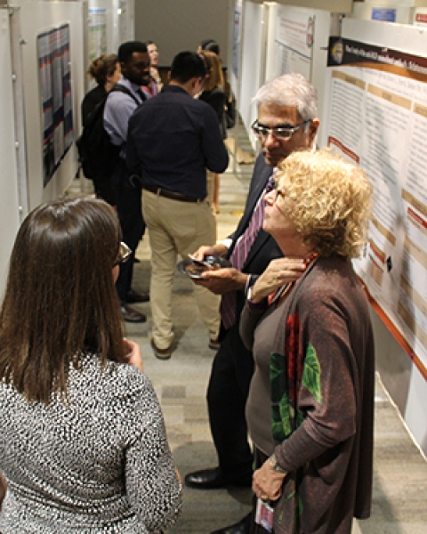 Drs. Christine Laukaitis, Deb Meyers and Sai Parthasarathy confer over a research poster