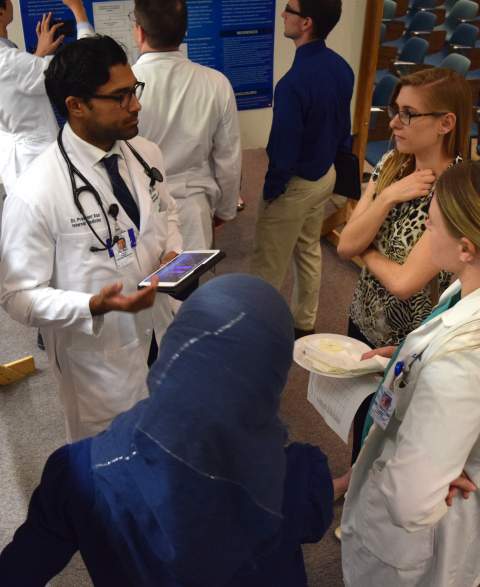 Internal medicine residents at the University of Arizona discuss a poster project on cardiology