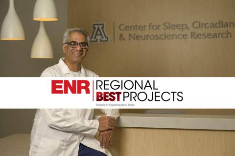 Sai Parthasarathy, MD, in lobby of Center for Sleep, Circadian & Neuroscience Research at UArizona Health Sciences with white strip across image with verbiage, "ENR Regional Best Projects"