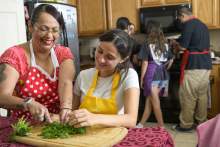 [A Hispanic family in a kitchen preparing a healthy meal together]
