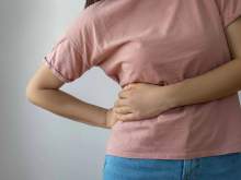 [Image of a woman holds her side as if in pain, illustrating a paper with published results on a clinical trial led by University of Arizona Health Sciences researchers found that a three-drug chemotherapy treatment for advanced stage, inoperable biliary tract cancers didn’t improve patient survival when compared with the standard two-drug treatment. (Photo by Bymuratdeniz via Getty) ]