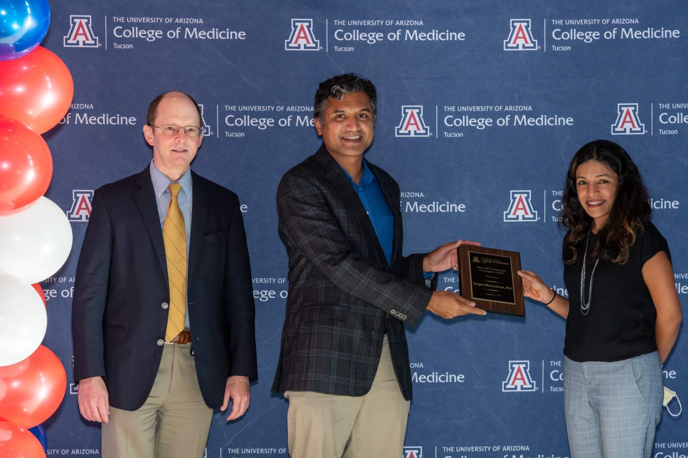 [Dr. Deepta Bhattacharya is presented with the Research Excellence Awards by Dr. Jason Wertheim and Dr. Rachna Shroff.]