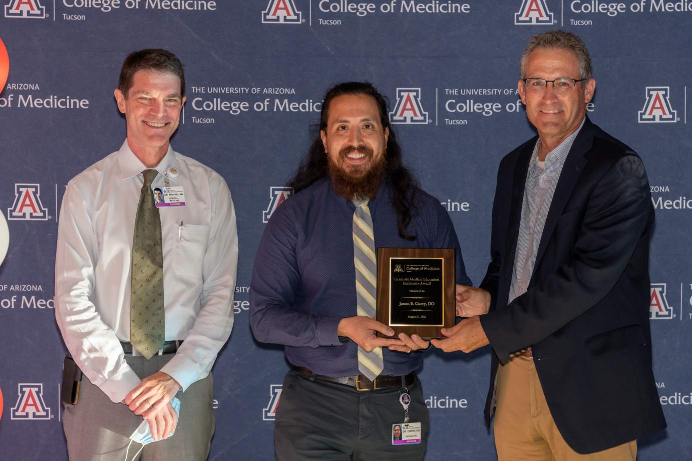 [Dr. Jason Curry is presented with the Award for Excellence in Graduate Medical Education by Dr. Kevin Moynahan and Dr. Conrad Clemens.]