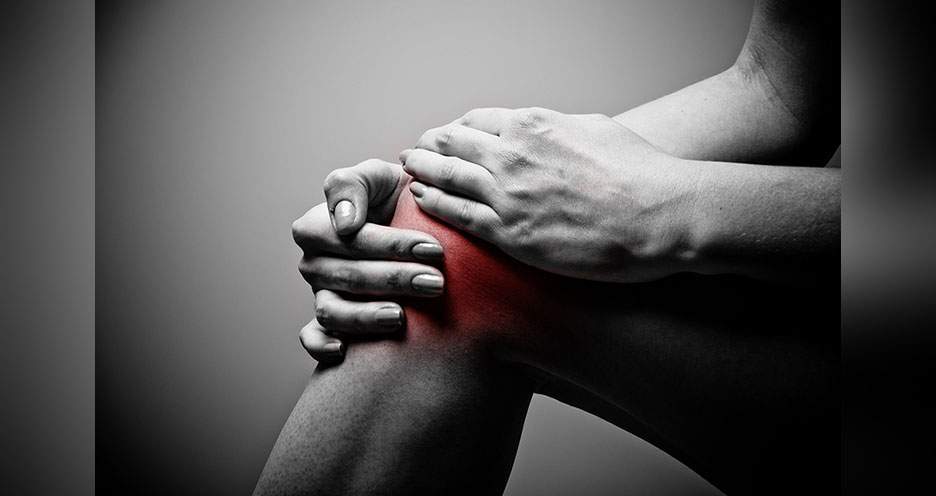 [Black-and-white image of man holding knee with red glow around knee as if in pain]