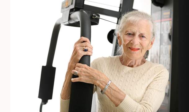 [Older woman in beige sweater with exercise machine]