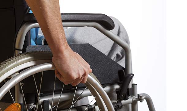 [Image of man's hand on wheel of wheelchair]