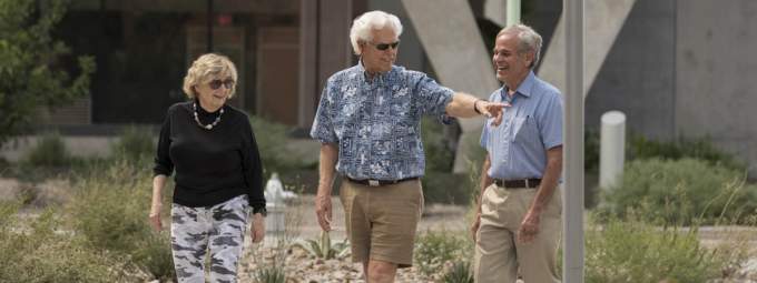 [Three older adults walk through the University of Arizona Health Sciences campus]