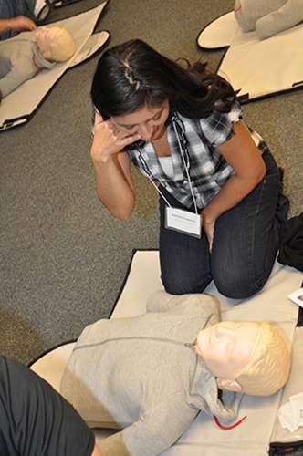 [Student learning to give CPR on a dummy]